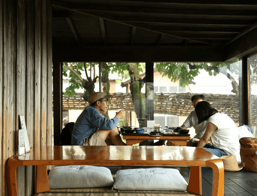 group gathering around a wooden table on a porch