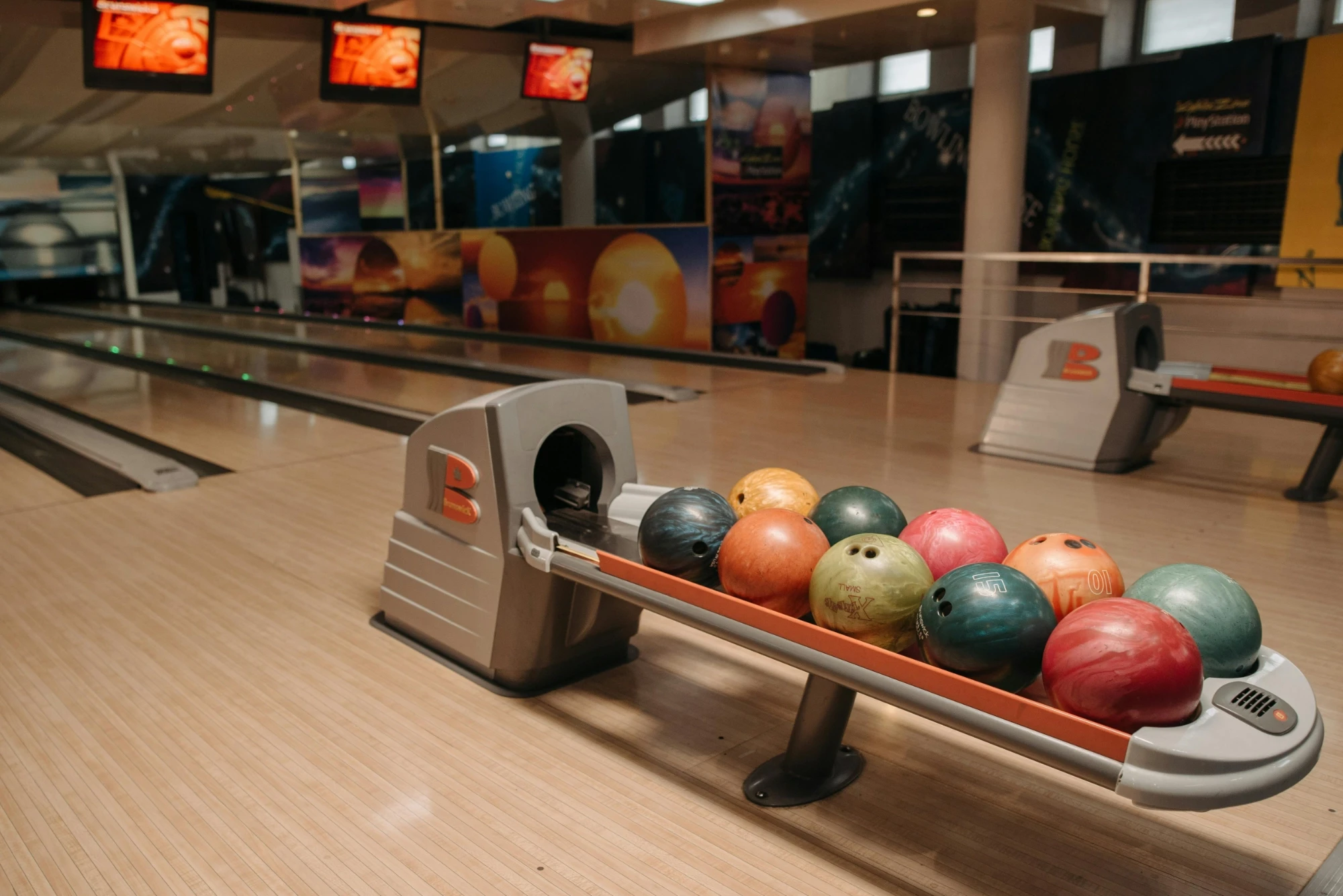 a retro bowling alley with coloured balls lined up and ready to go