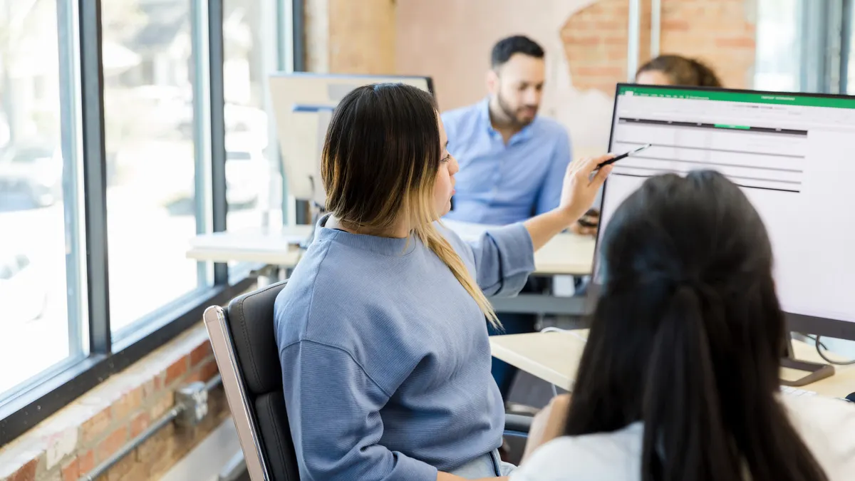woman pointing at computer - How to Lock Rows in Excel for Sorting