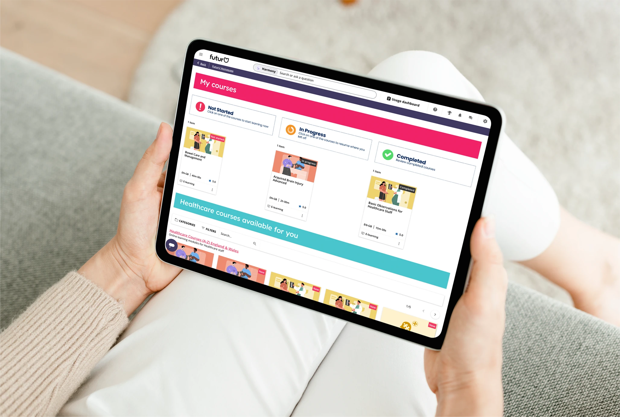 Hands holding a tablet showing the FuturU learning platform, with course cards for not started, 'in progress and completed healthcare training modules.