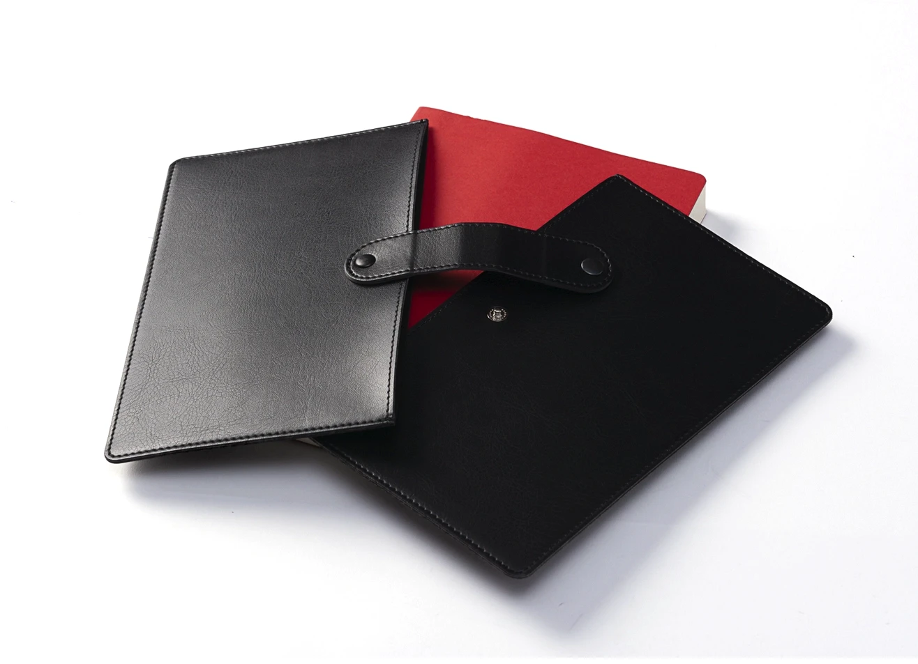 View of the black leatherette cover separated from the red notebook refill.