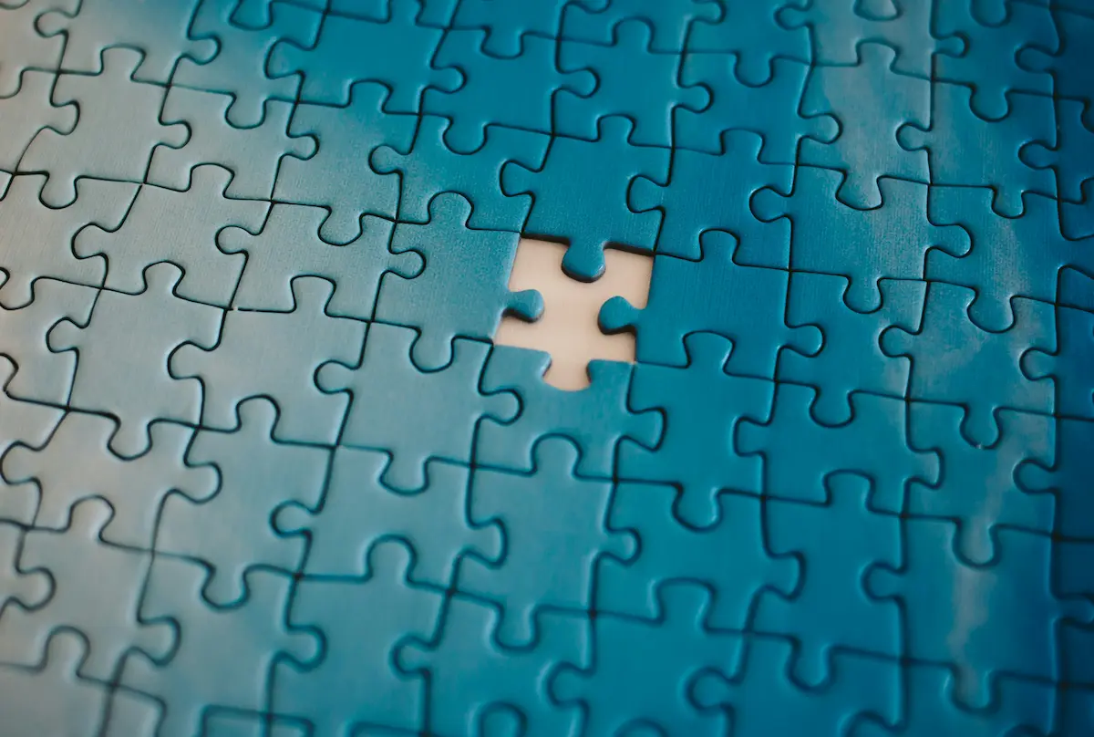 Blue puzzle with a single missing piece, representing uncertainty and unanswered questions.