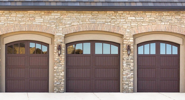 These carriage house wood-panel doors use a classic swing-open appearance with the modern-day convenience of a sectional garage door.