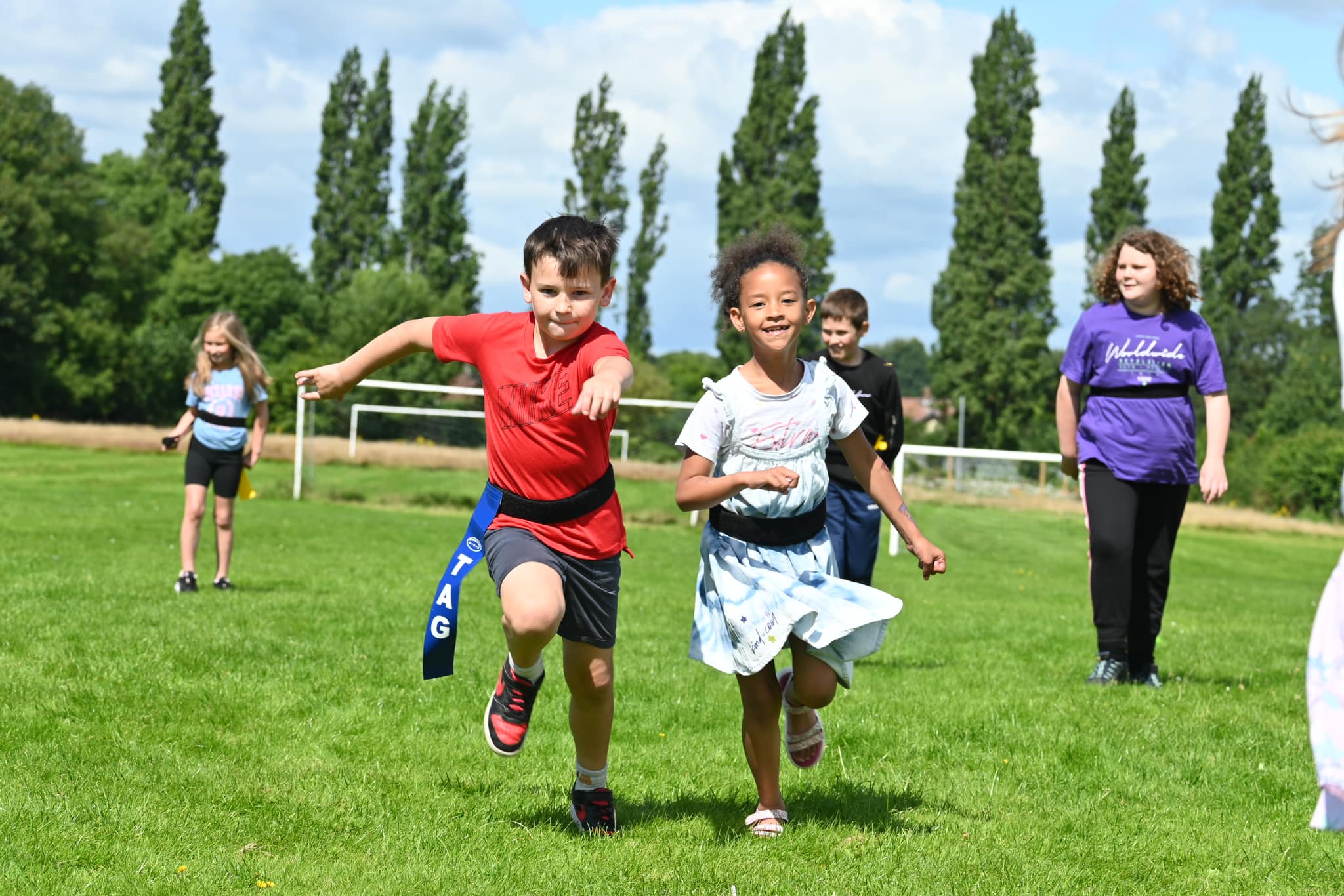 two young girls hugging each other on a field