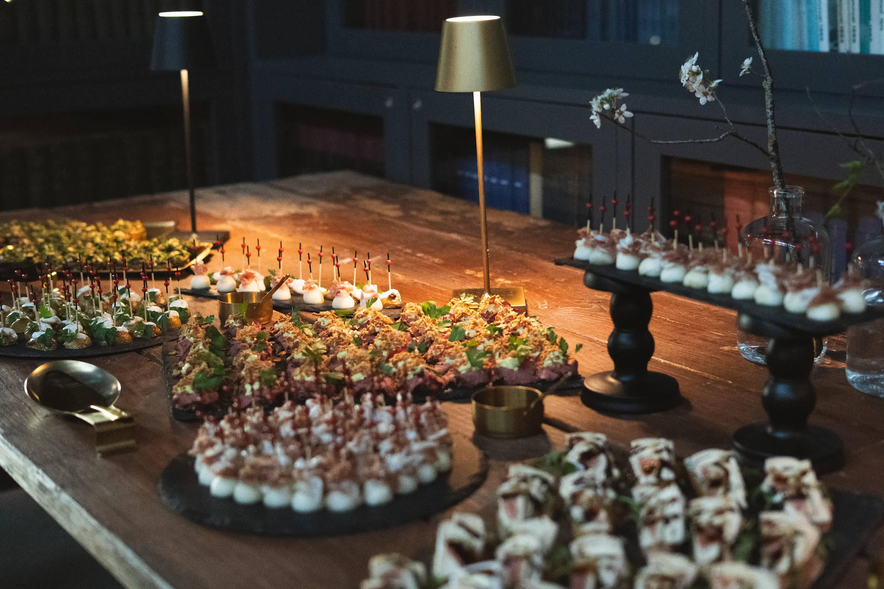    Hochwertiges Catering Buffet mit Fingerfood und stilvoll angerichteten Speisen auf Holztisch