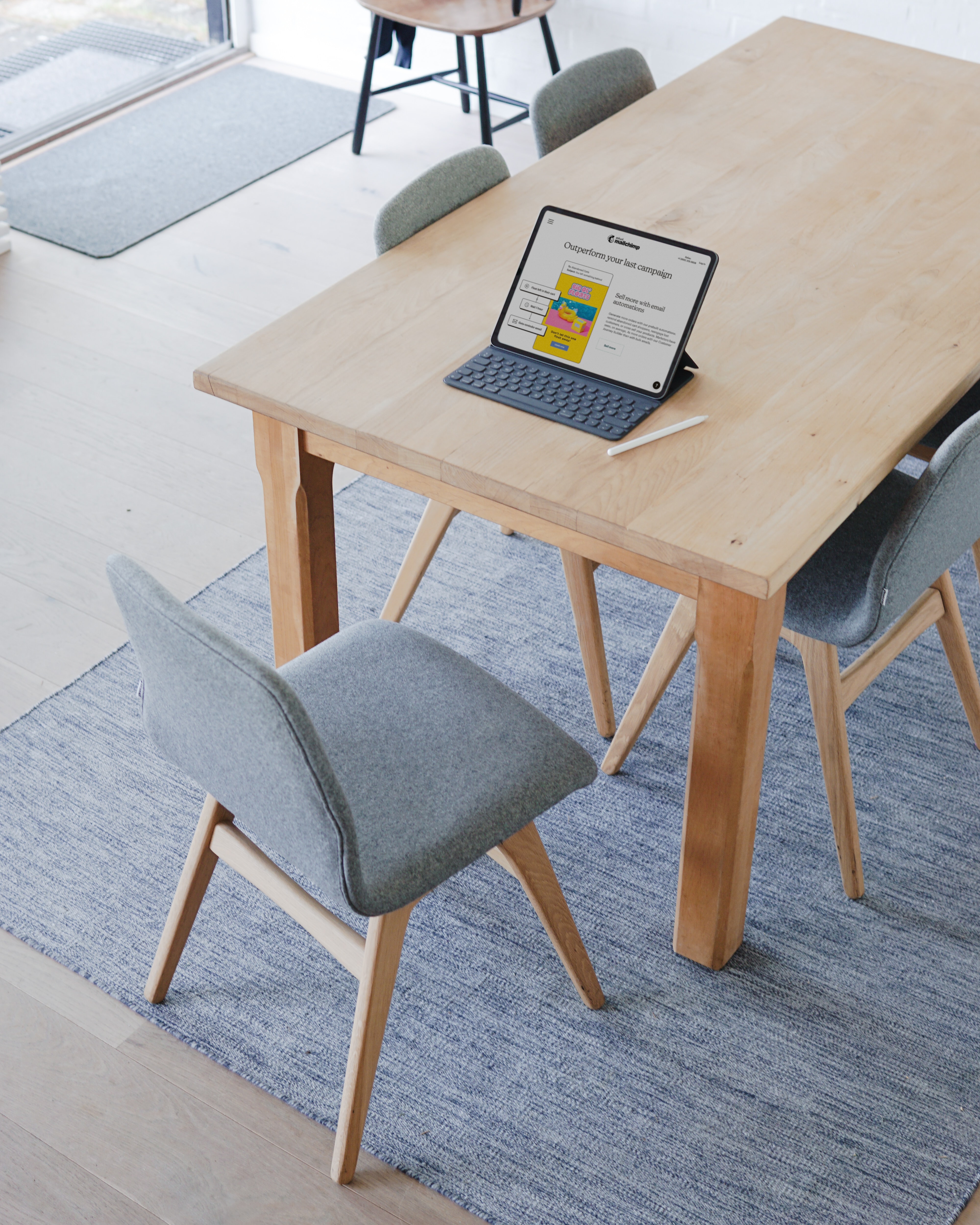 ipad sitting on a wooden table with grey chairs