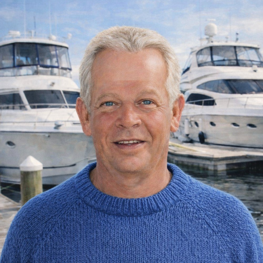 Older gentleman standing on a dock with yachts behind him