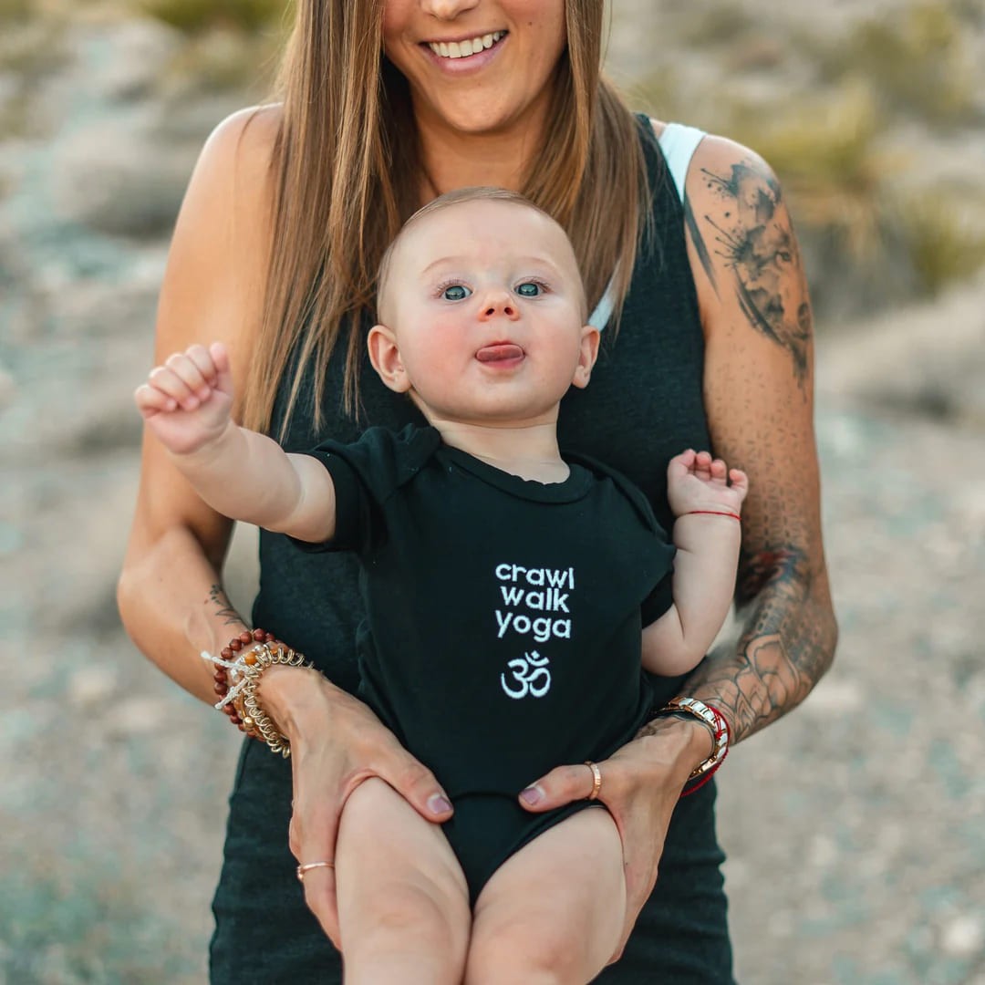 Bre and baby wearing Breathe and Flow merchandise.