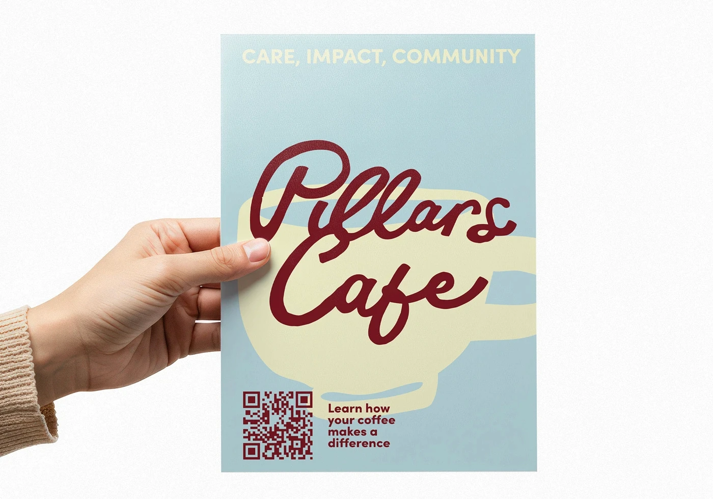 Hand holding a Pillars Cafe information flyer with a large illustrated coffee cup and QR code.