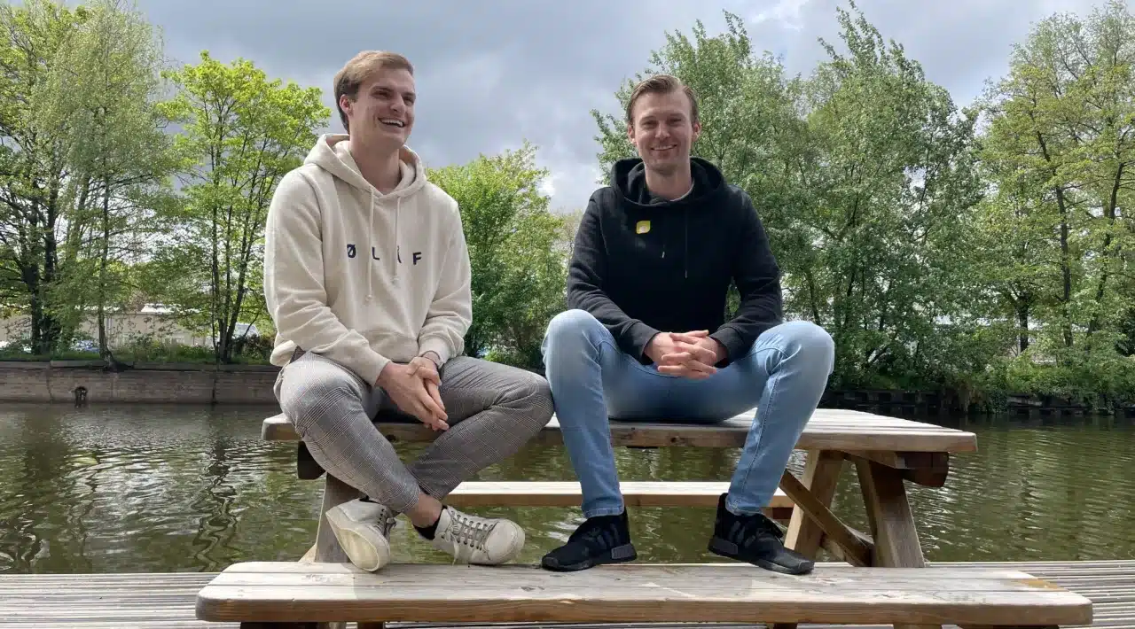 Dylan Laseur and Robin Laseur of Flatline Agency sitting on a picnic bench by the water