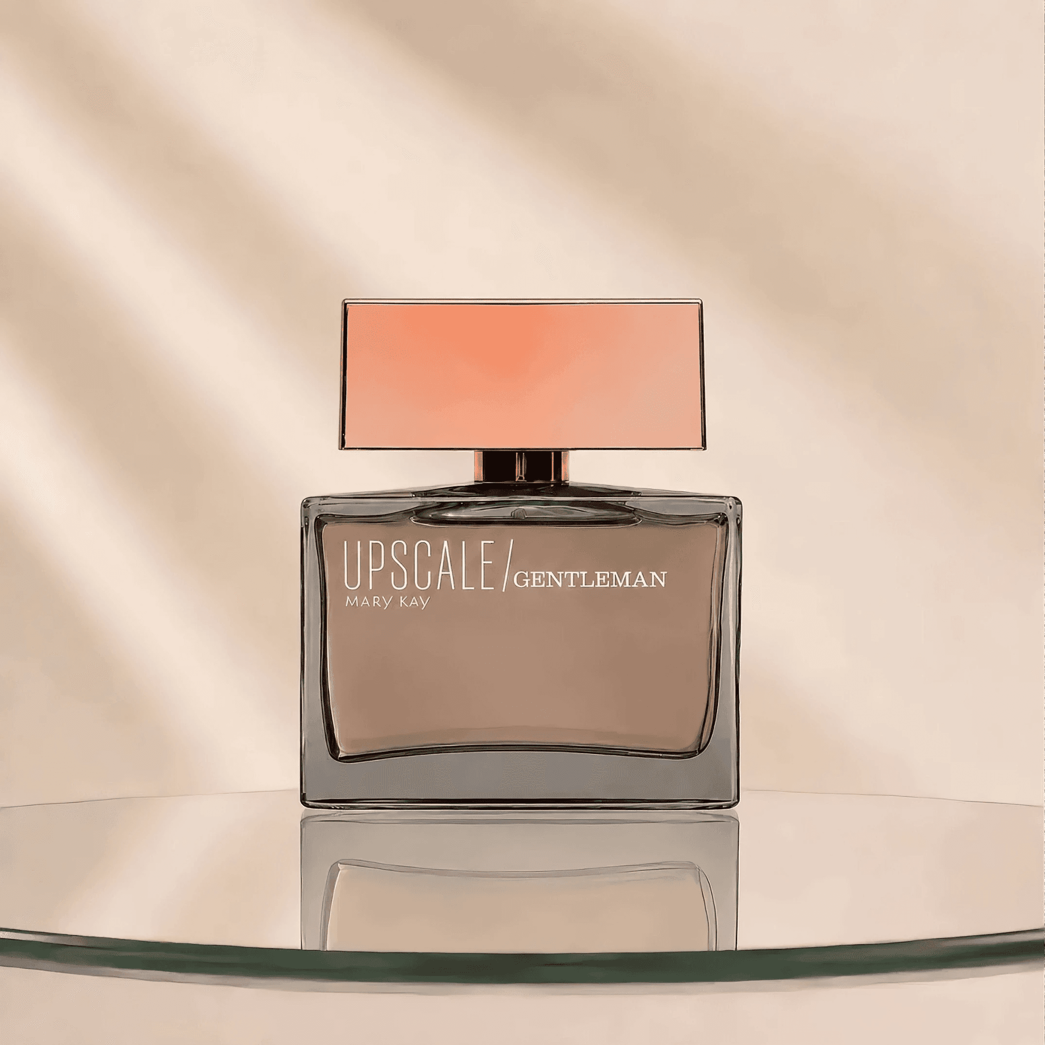 Frasco transparente em tom taupe da Upscale Gentleman® Deo Parfum Mary Kay sobre base de vidro e fundo bege.
