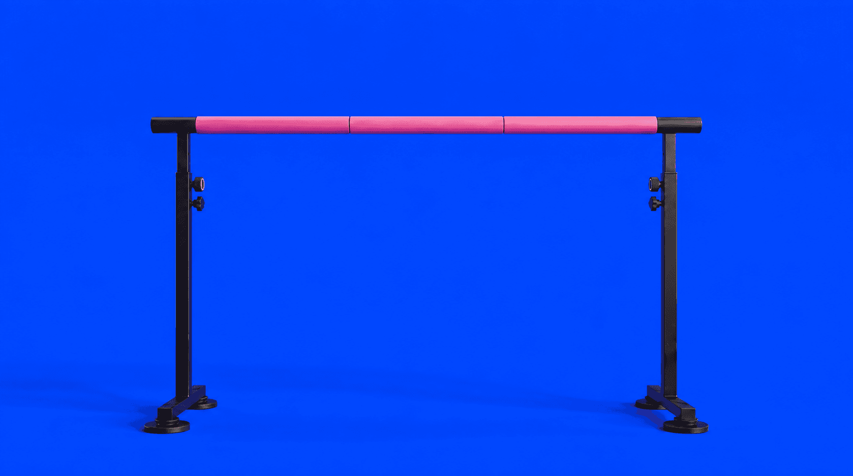 Ballet barre with a black frame, soft pink covering, height adjustment controls, and four suction cups at the base.