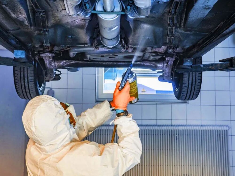Workers are spraying car chassis paint