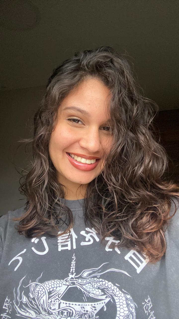 A smiling happy customer with curly hair on a blue background