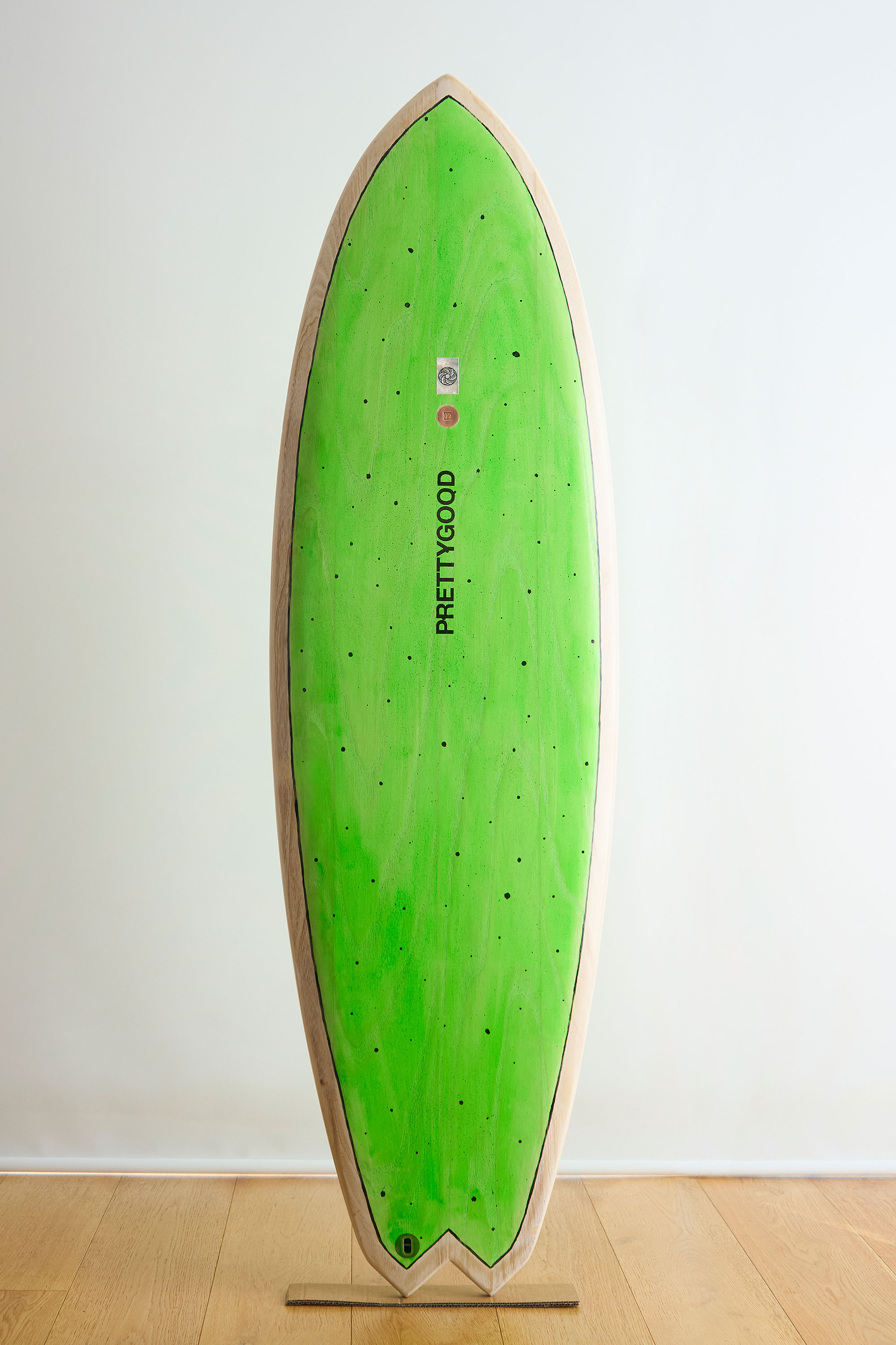 Bright green and white wooden surfboard