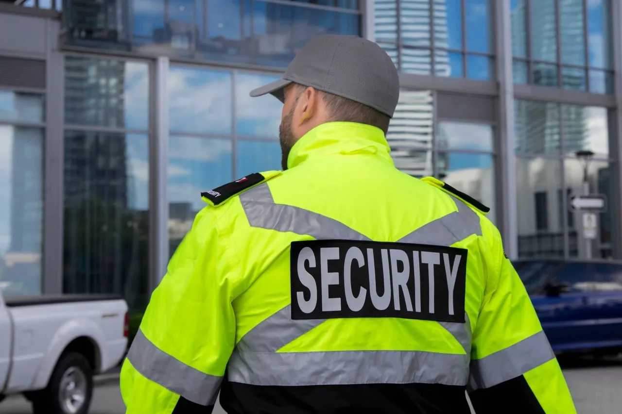 Rear view of a security guard in high visibility uniform patrolling a residential area.