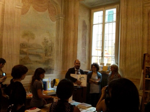 Pietro holding a book showing to students