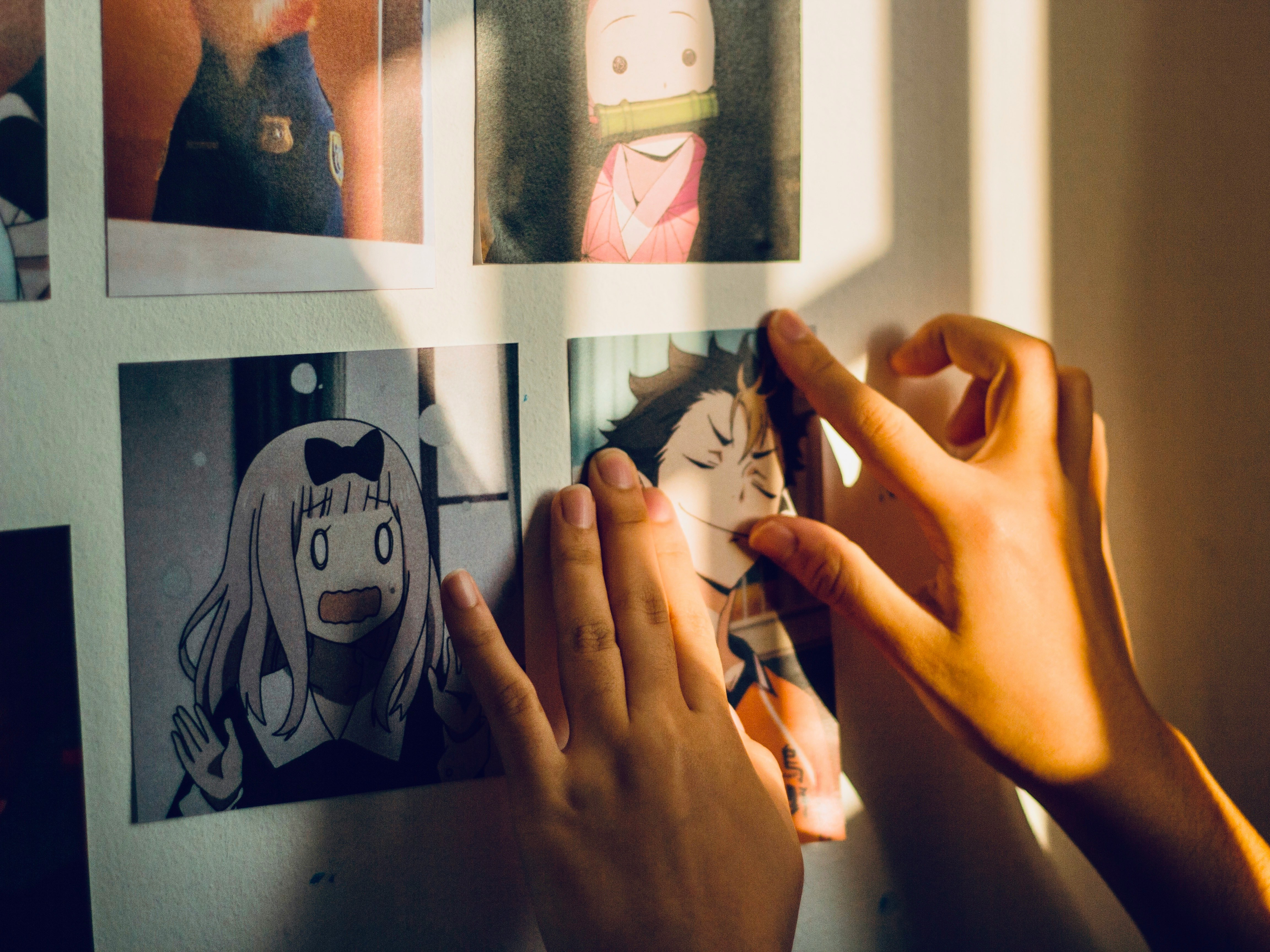person putting anime portaits on wall - Anime Ai Voice Generator