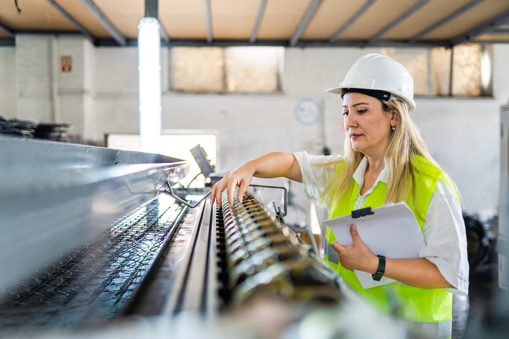Fabrikarbeiterin kontrolliert Maschine