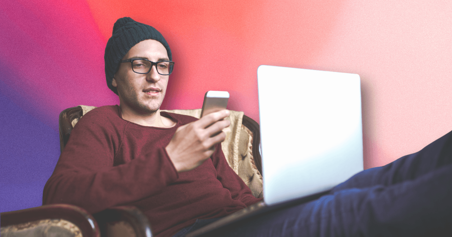 A man with a phone and laptop paying a bill