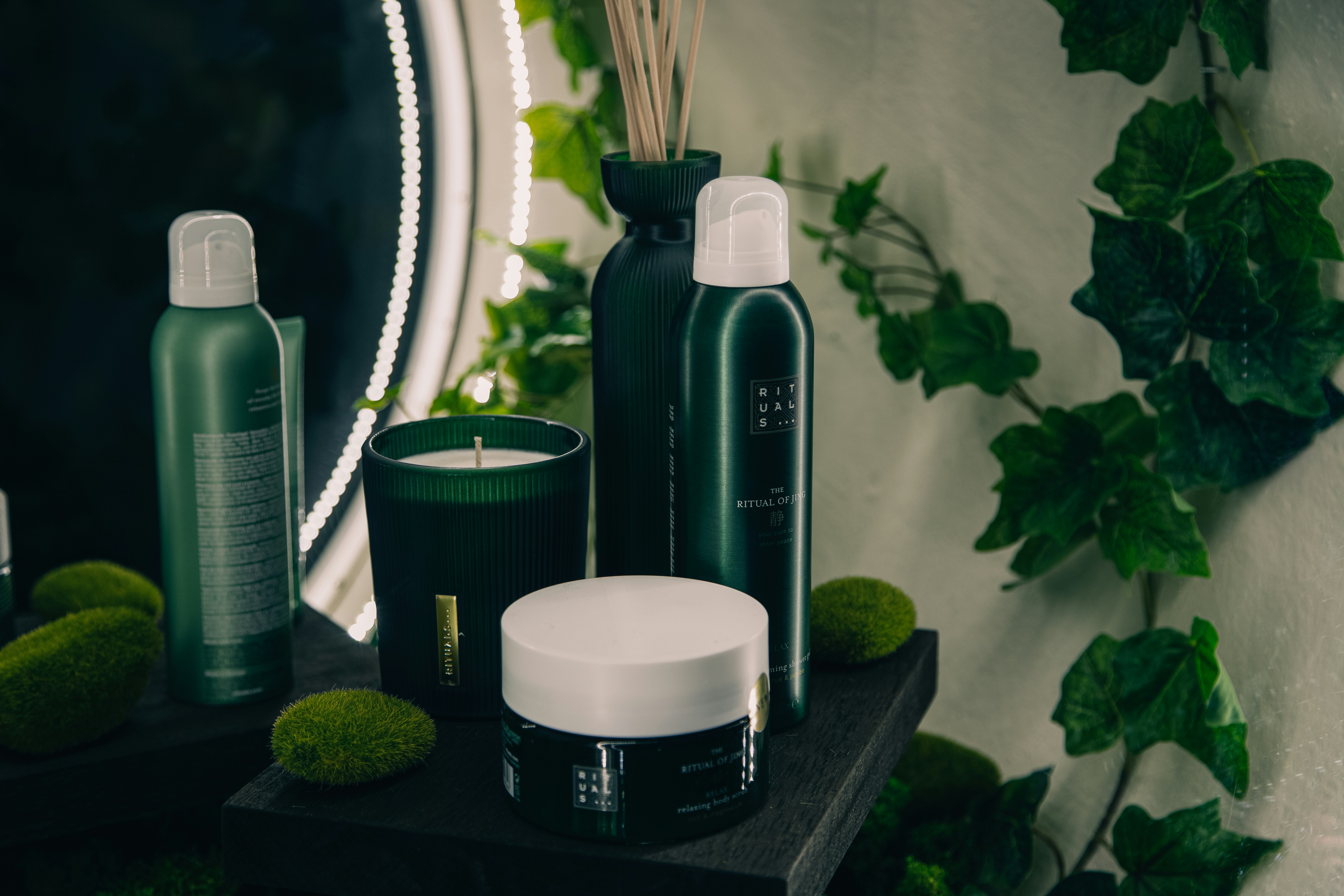 a table topped with bottles and candles next to a mirror