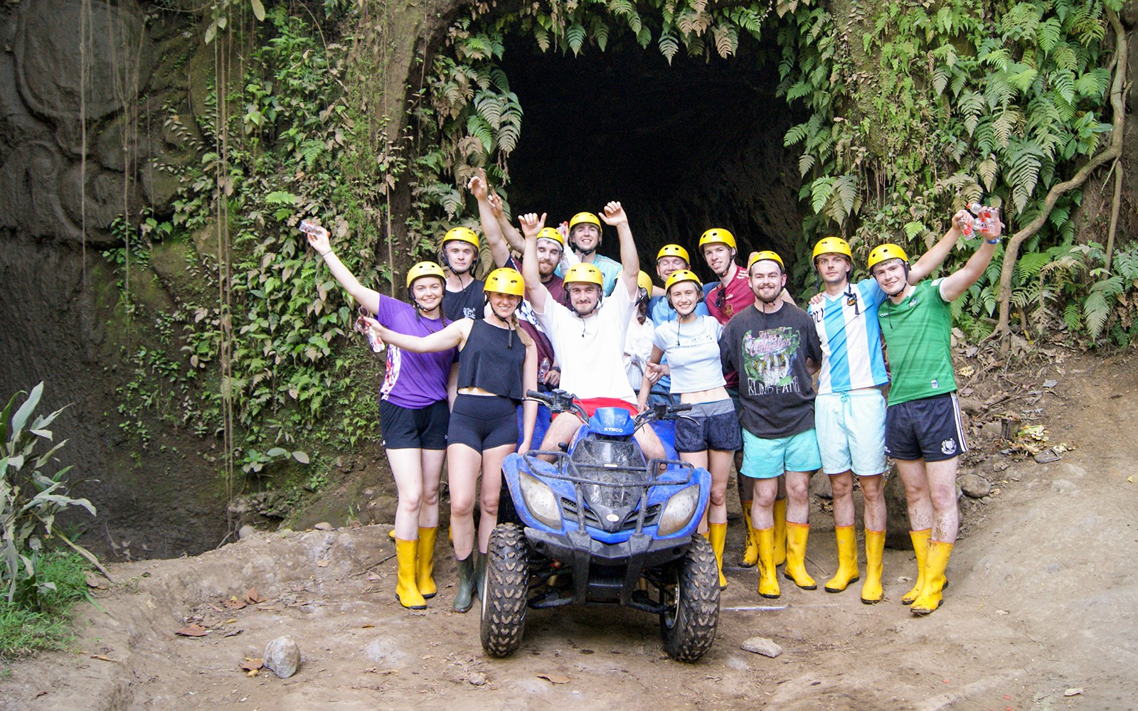 Group of people with helmets and boots on an ATV tour in Bali jungle.