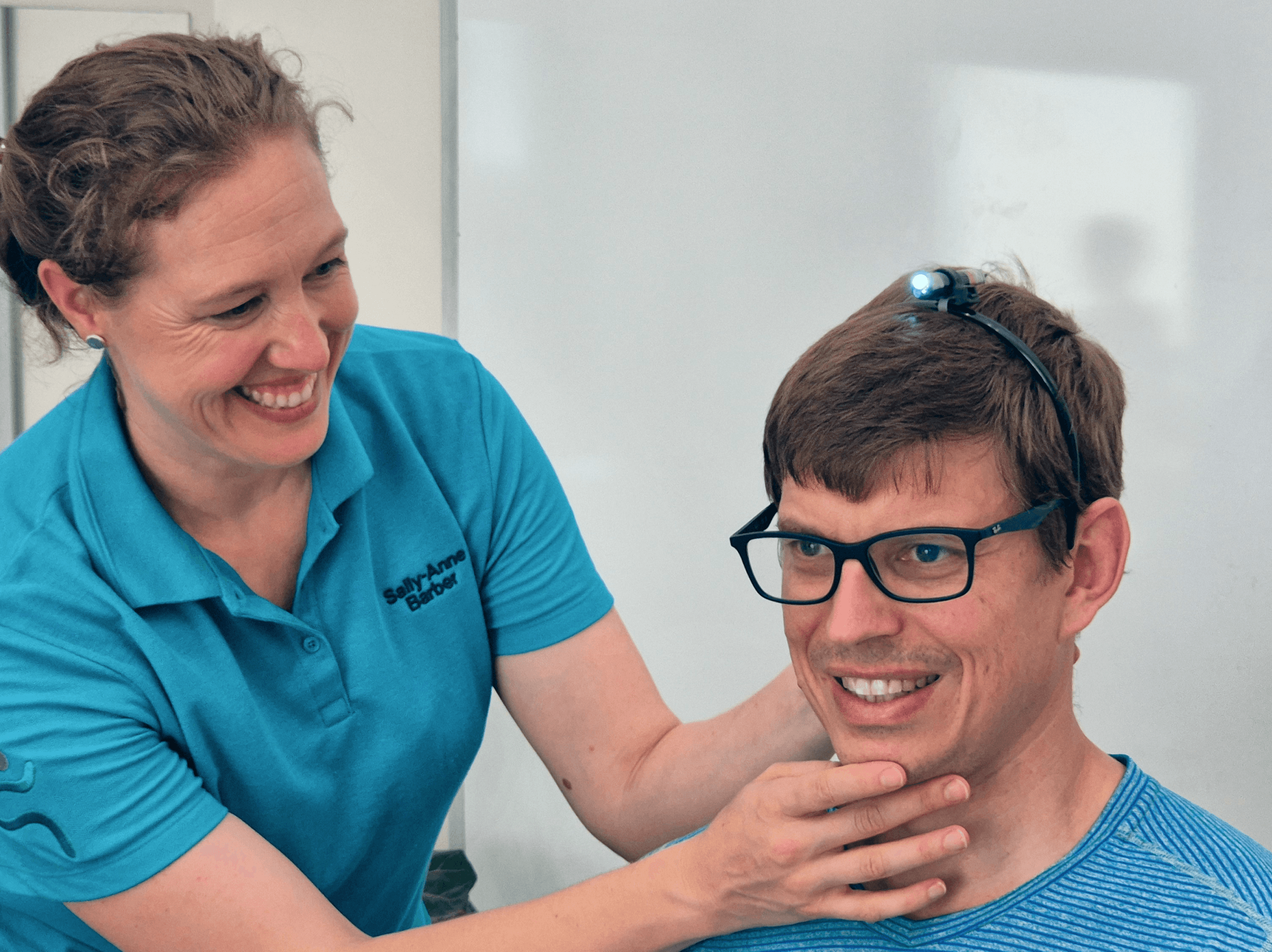 A Physiotherapist tests neutral neck position of a client by adjusting the chin of a male patient