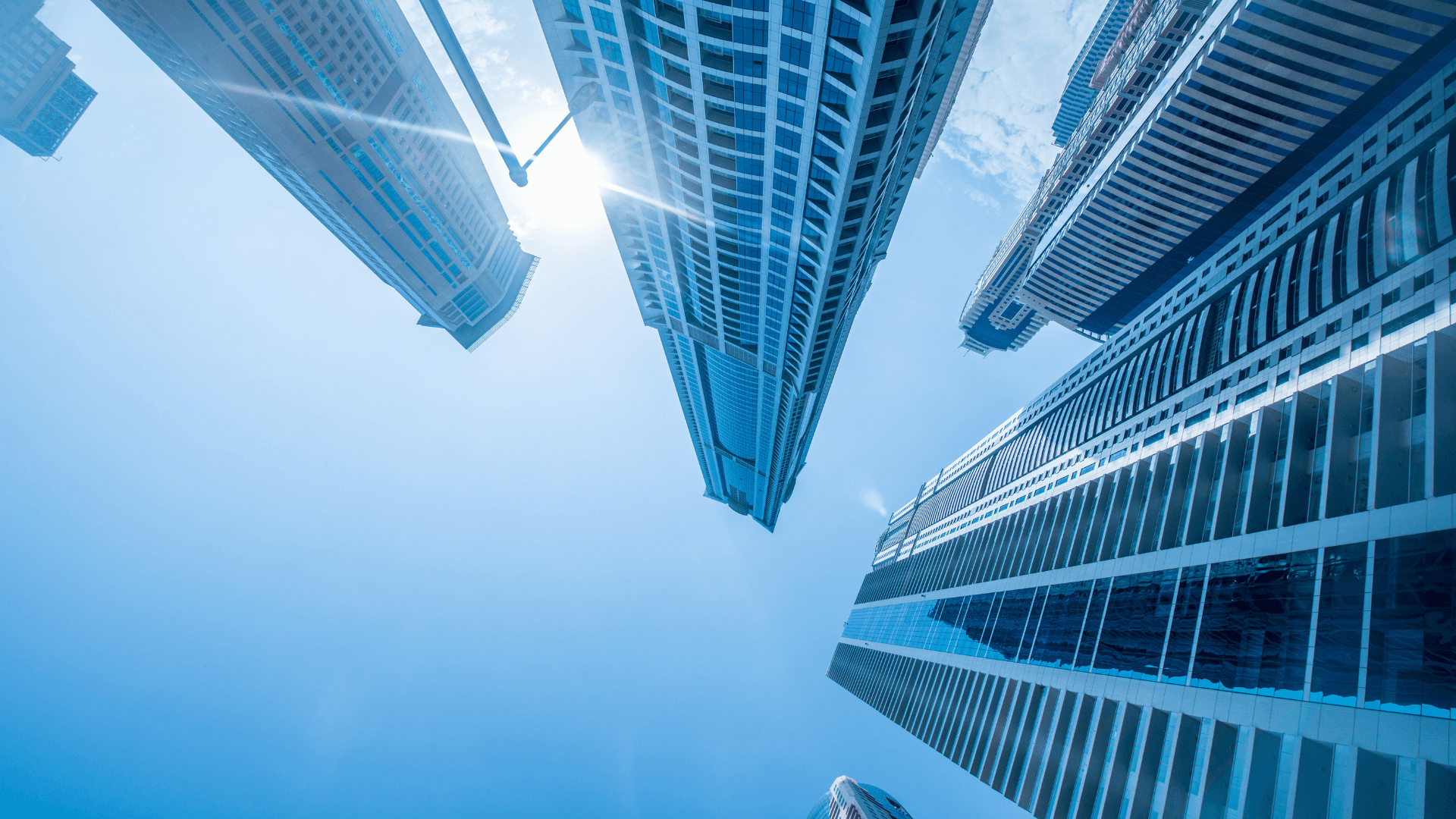 Modern skyscrapers shot from below with a clear sky, symbolizing growth and ambition | Lunasole Hospitality