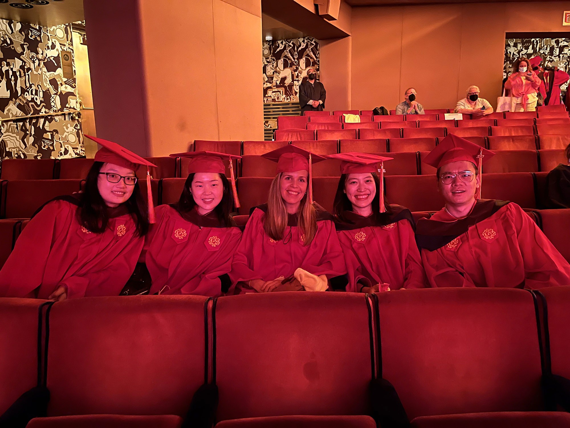 A group of SVA students, dressed in robes while sitting in a theatre hall, preparing for the SVA Graduation Ceremony.