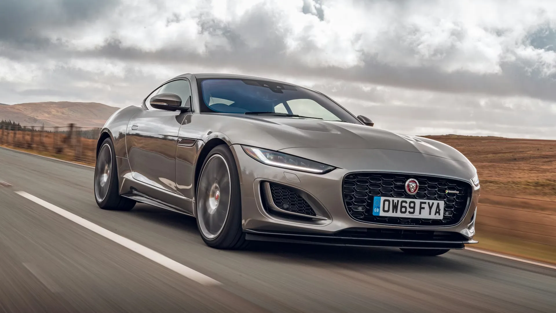 Grey performance coupe driving on a highway