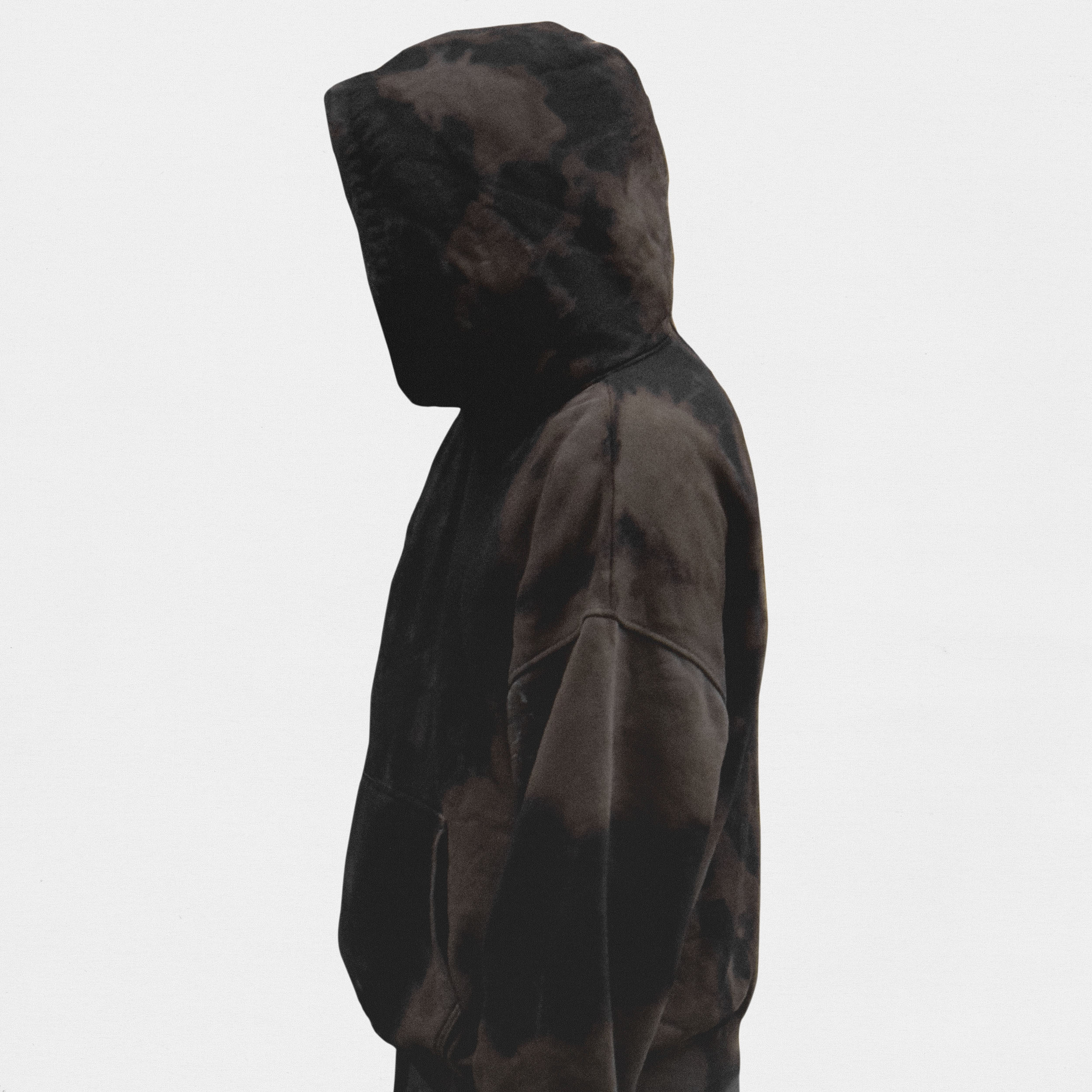 Model wearing brown hoodie on white background, portrait