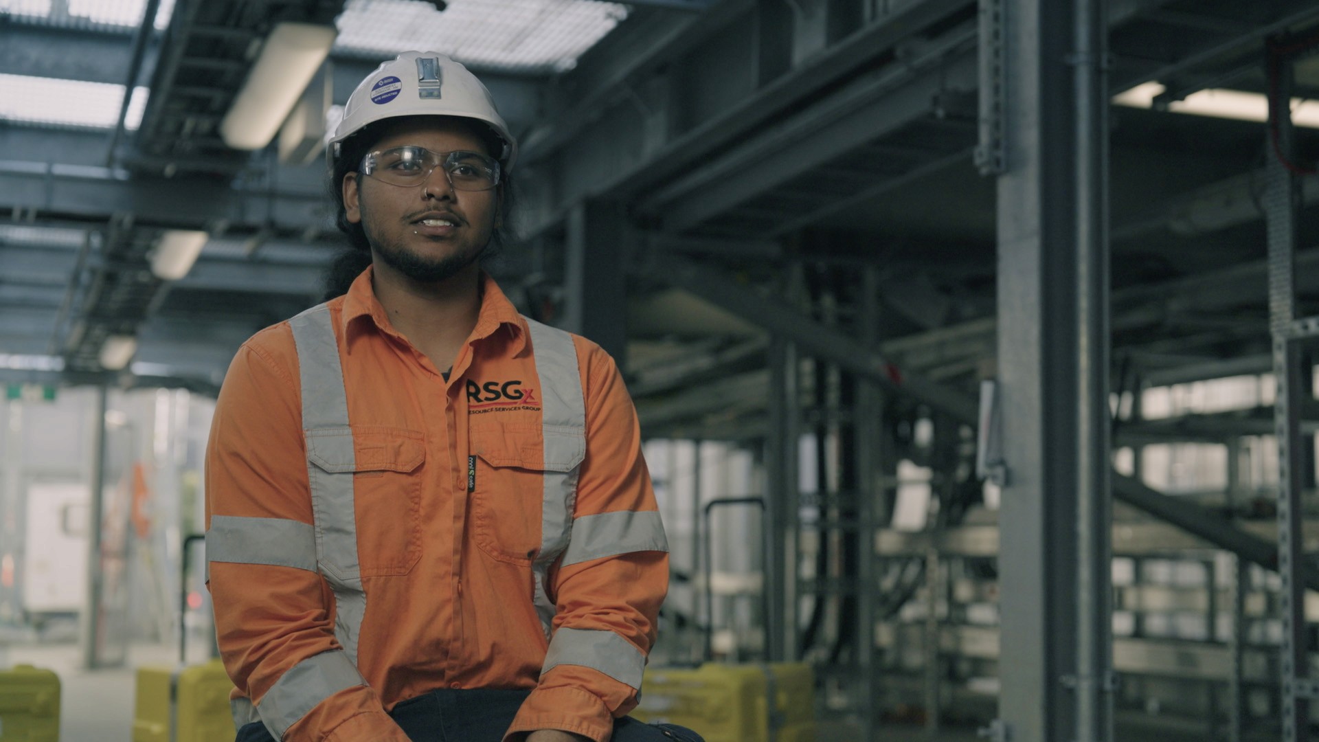 mid shot of man in safety gear sitting on tool box