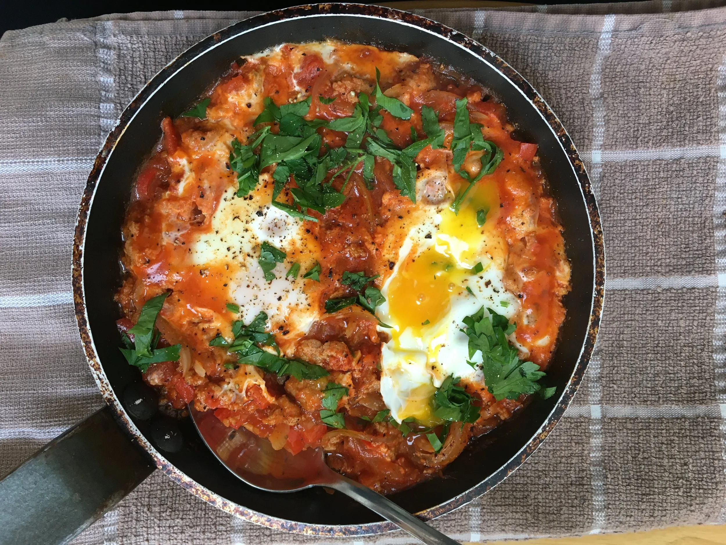 Eggs, chorizo and tomato in a fying pan