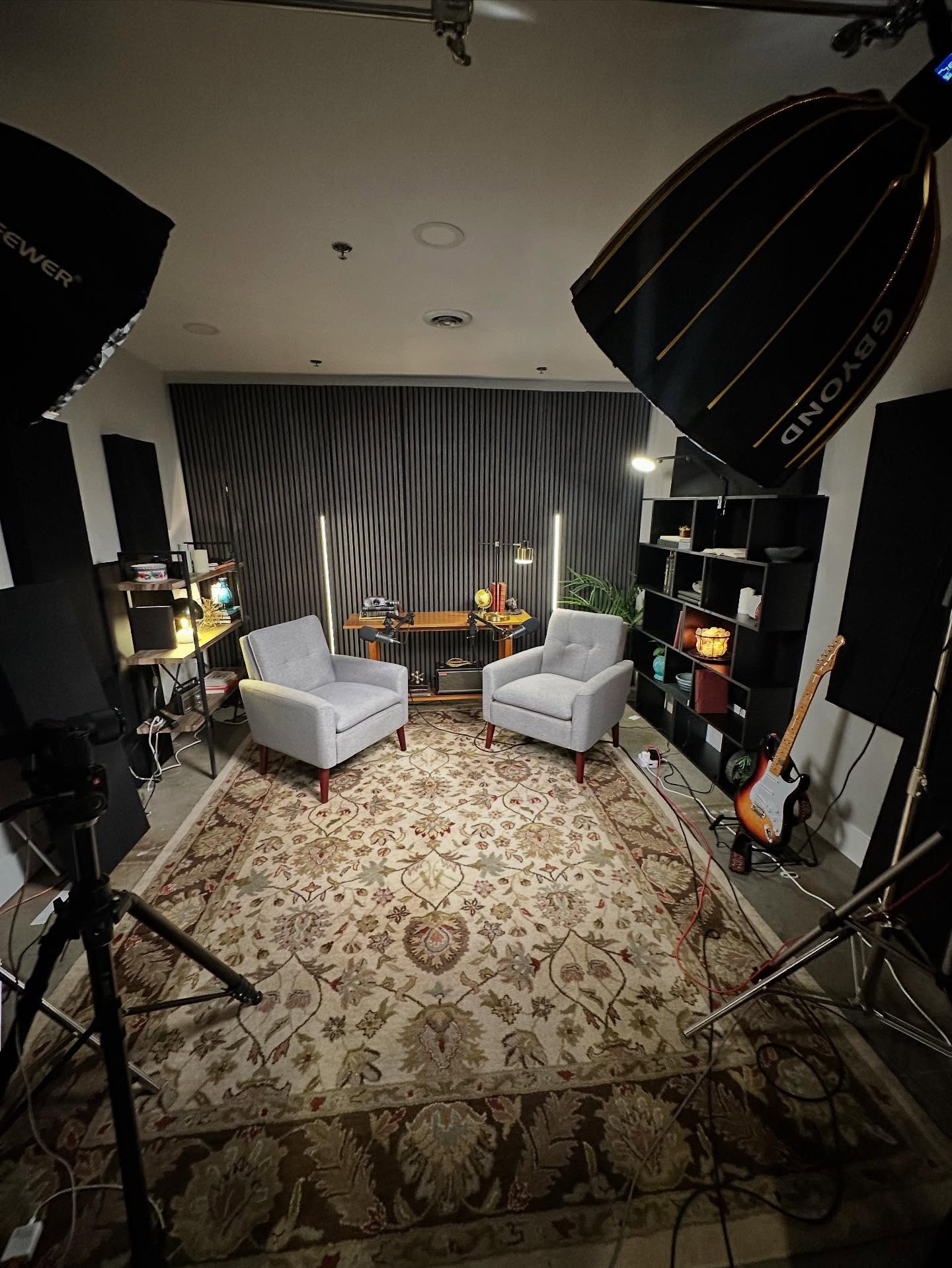 Wide shot of the postcasting studio. The lights dramatically light up the chairs in the center of the shot.