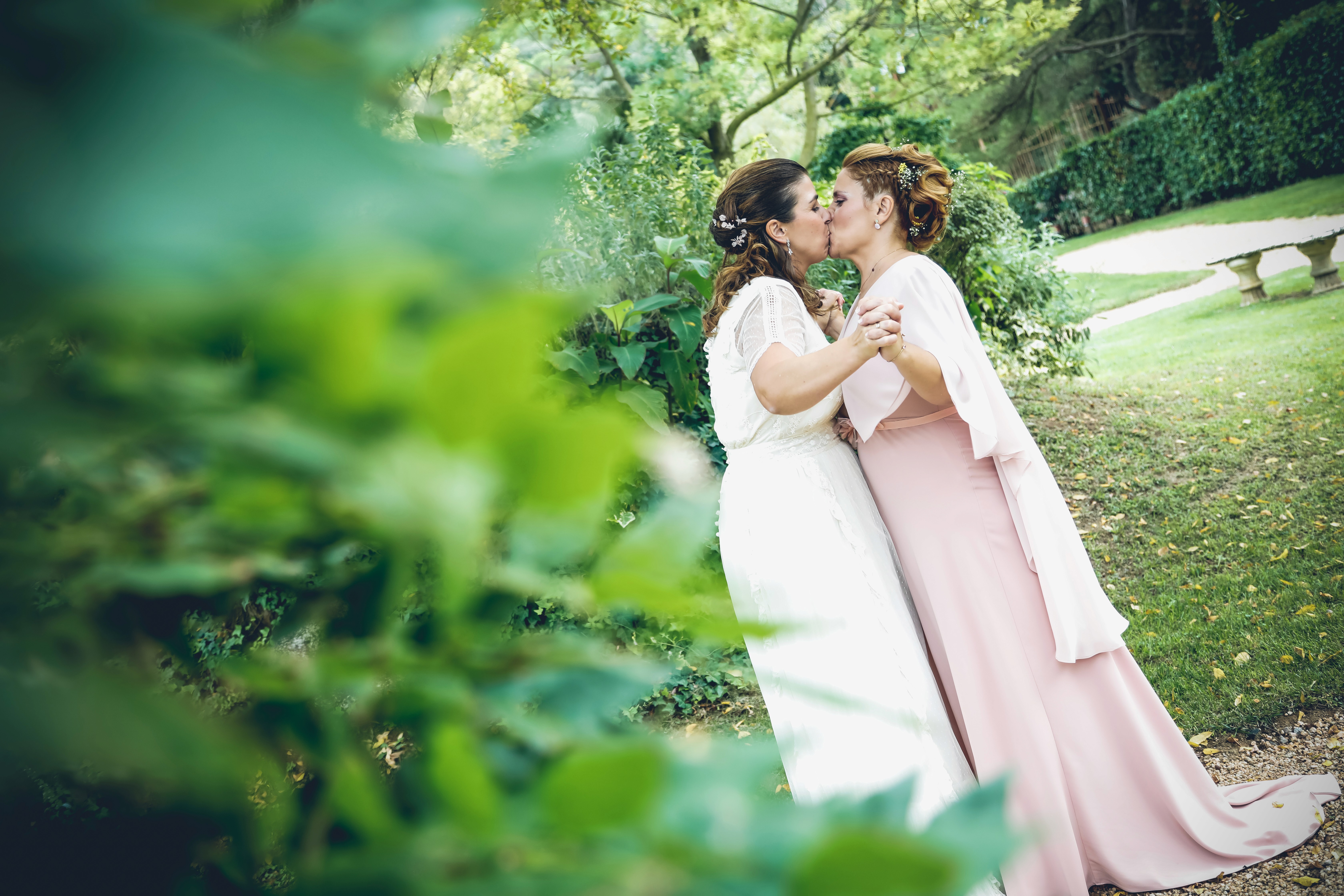 Sesión de boda. Pareja rodeada de plantas dandose un beso