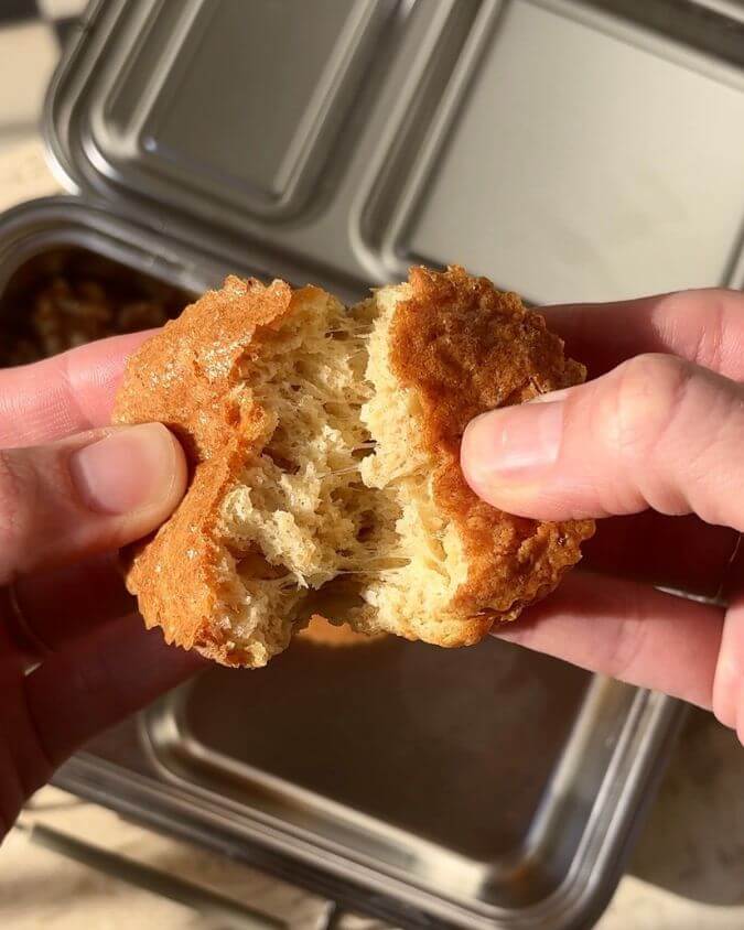 Cheesy muffin broken open showing soft, fluffy texture inside.