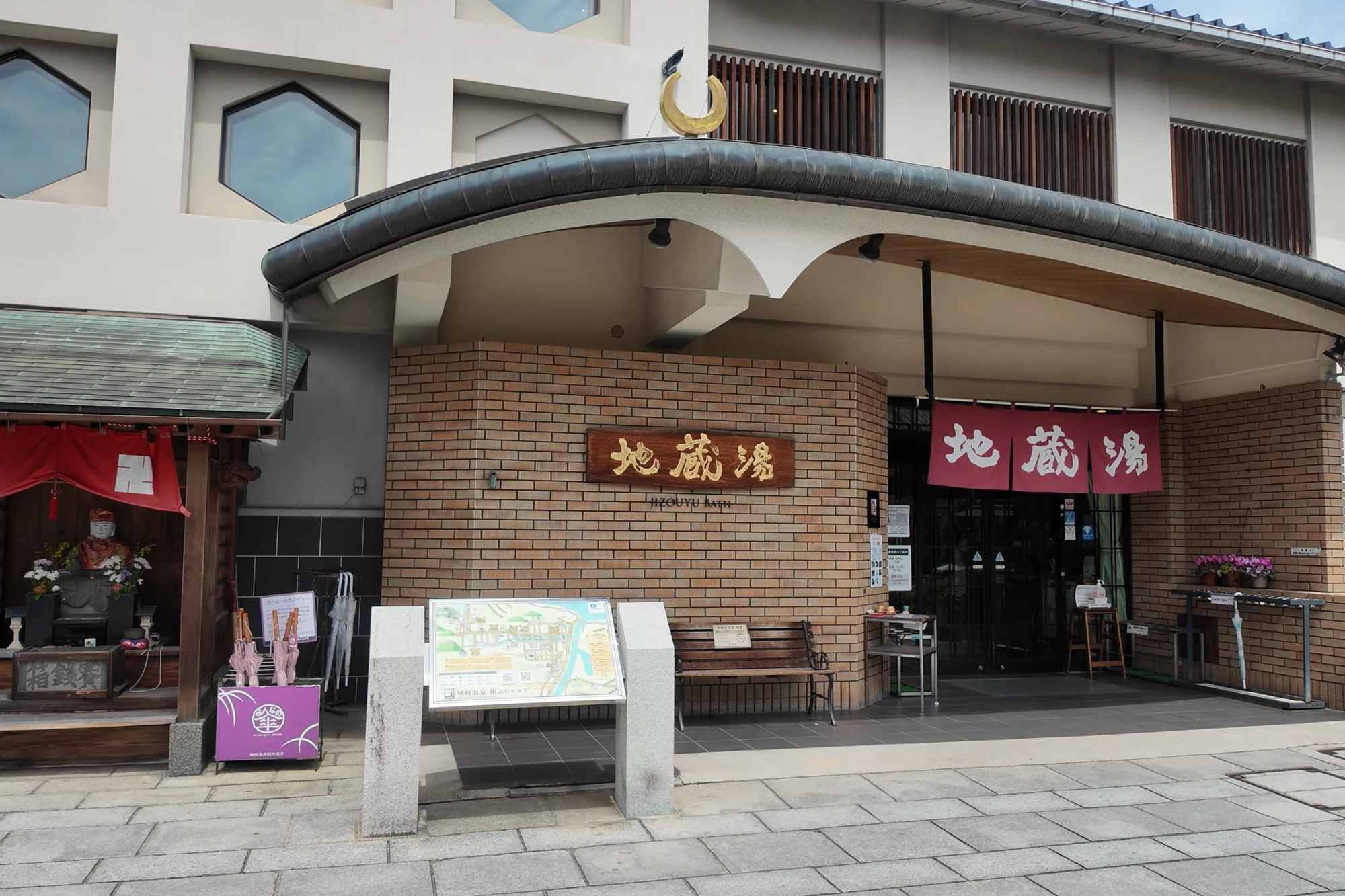 Jizo-yu bathhouse in Kinosaki with its name boards and a map panel beside the entrance.