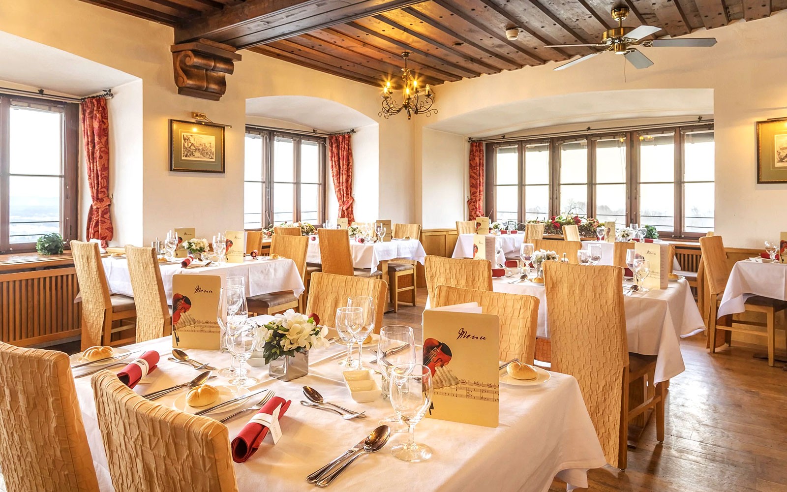 Dinner setup in Fortress Hohensalzburg dining room with tables and menus.