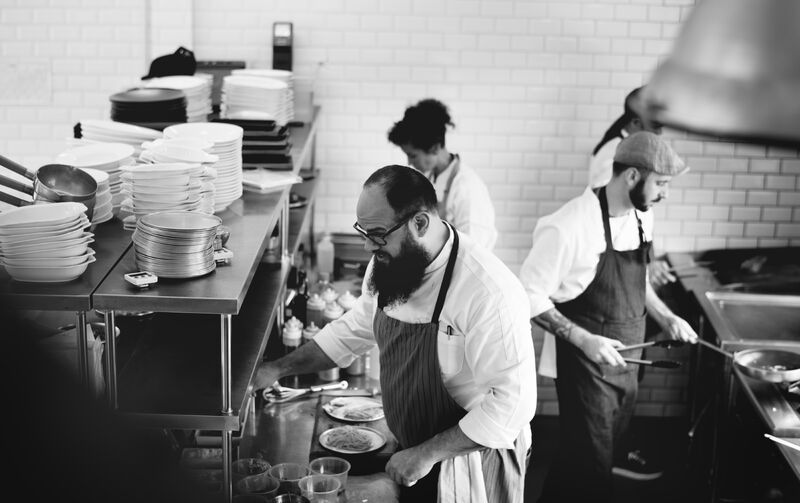 Des cuisiniers en train de préparer un plat dans une cuisine de restaurant