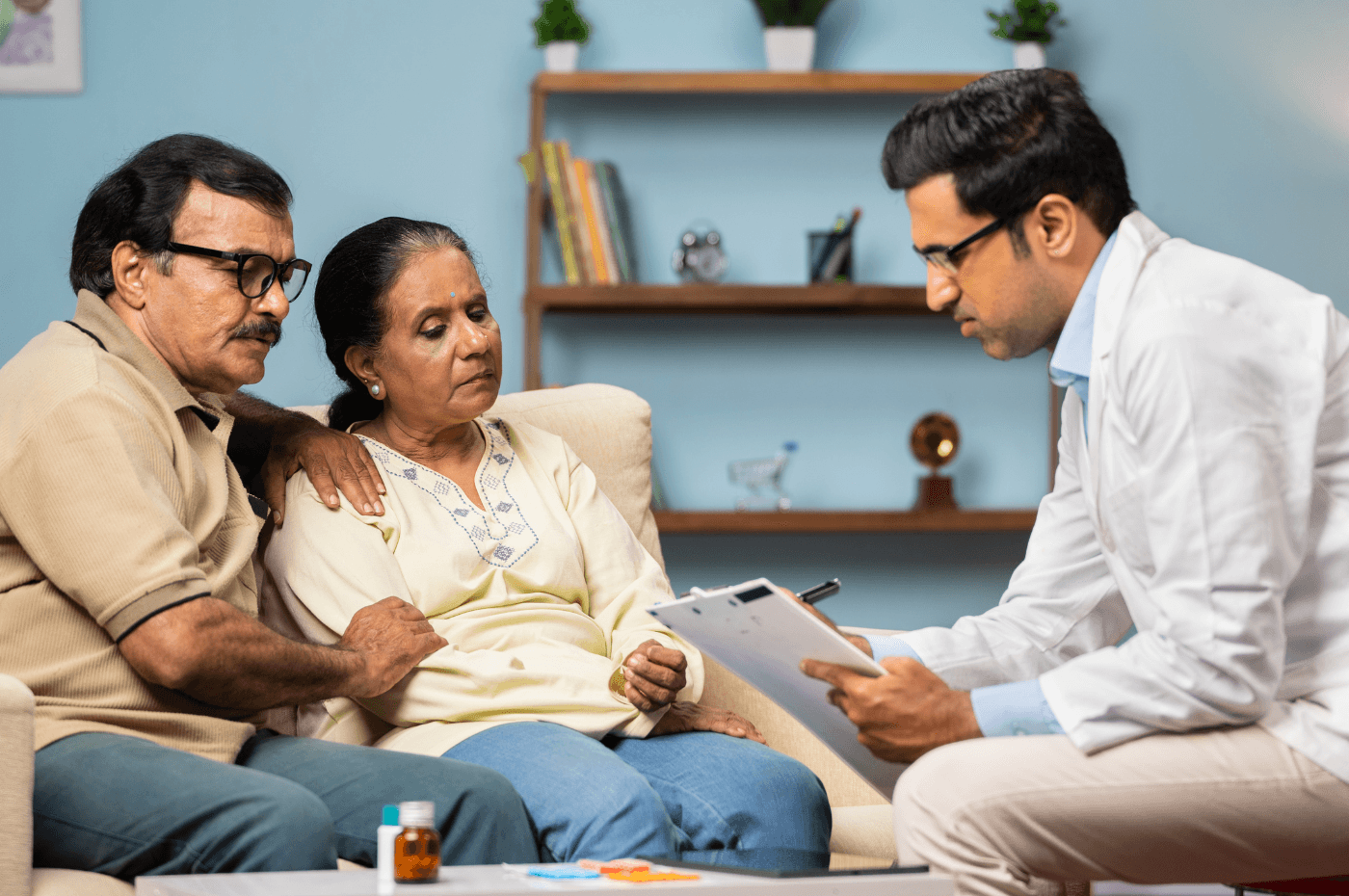 doctor advising senior couple while sitting on sofa at home