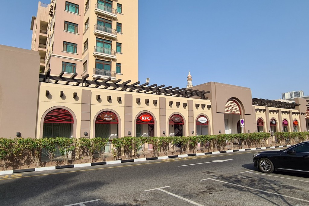 The Greens Community Mosque, a modern building with a dome and minaret, surrounded by greenery and community spaces.
