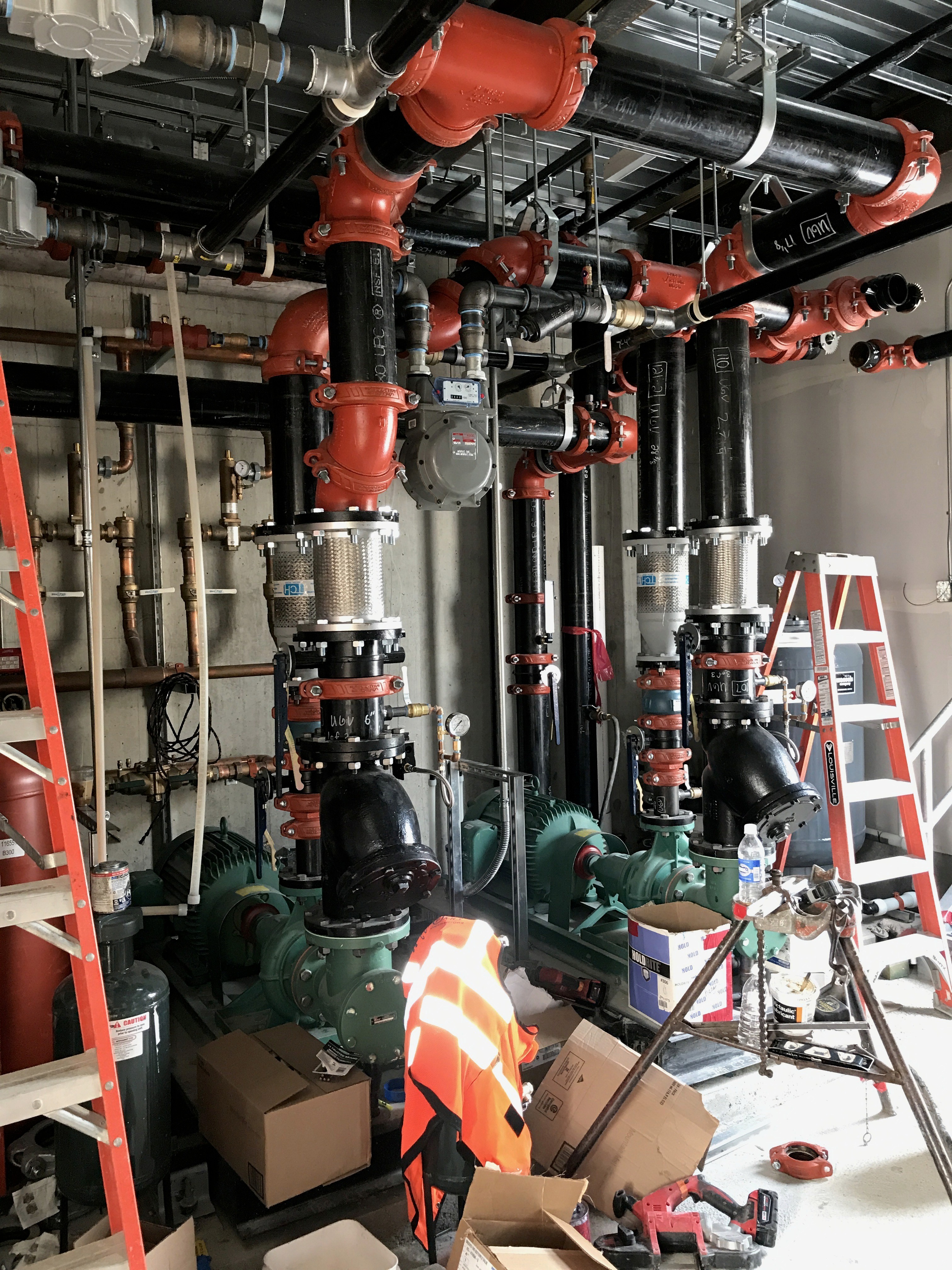 A winding road cuts through rocky terrain, surrounded by patches of green grass and illuminated by sunlight.