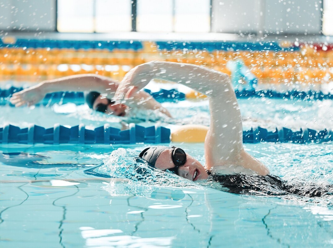 two women doing swimming for weight loss in a pool at the gym