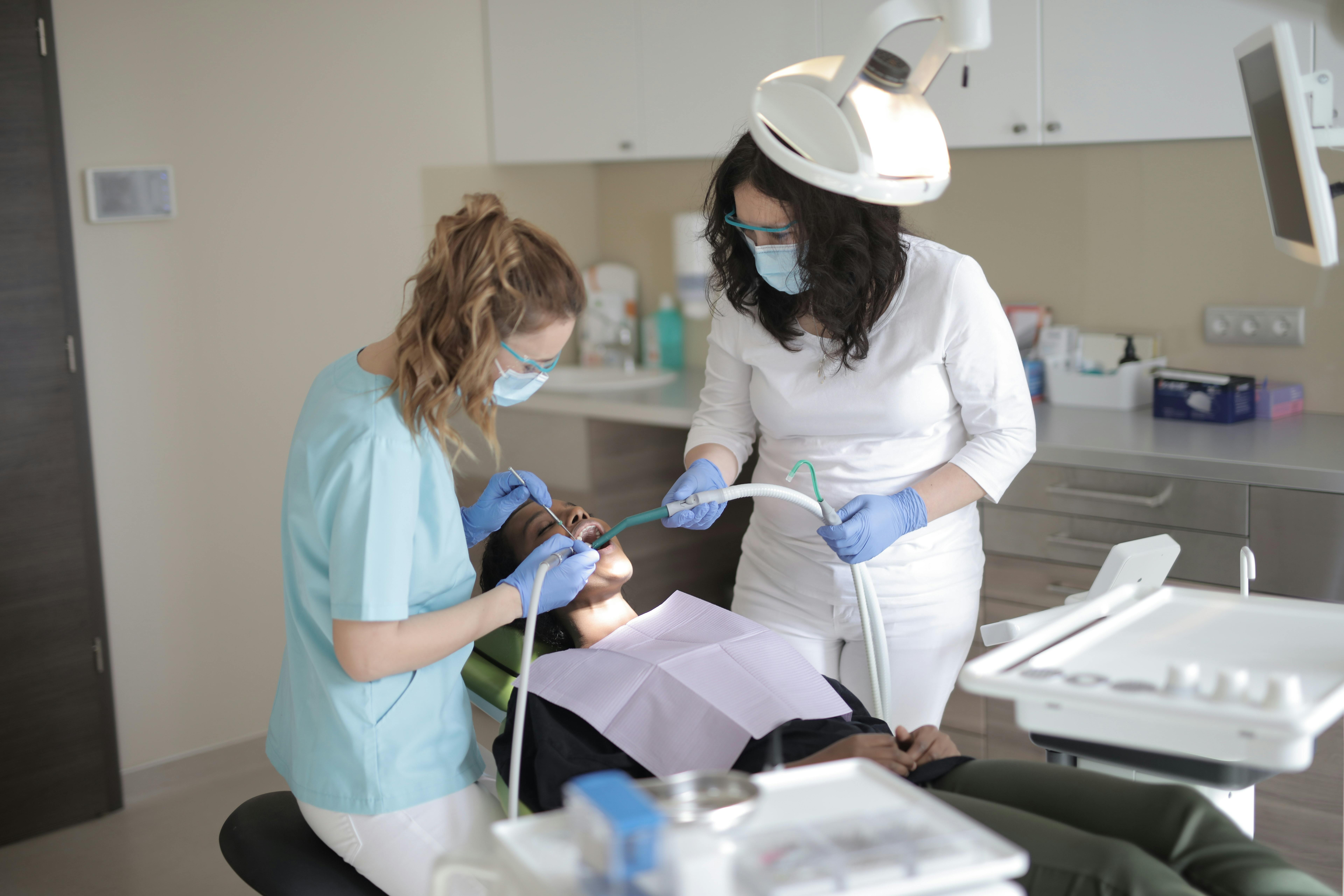 Dentist and dental hygienist work together on patient in chair
