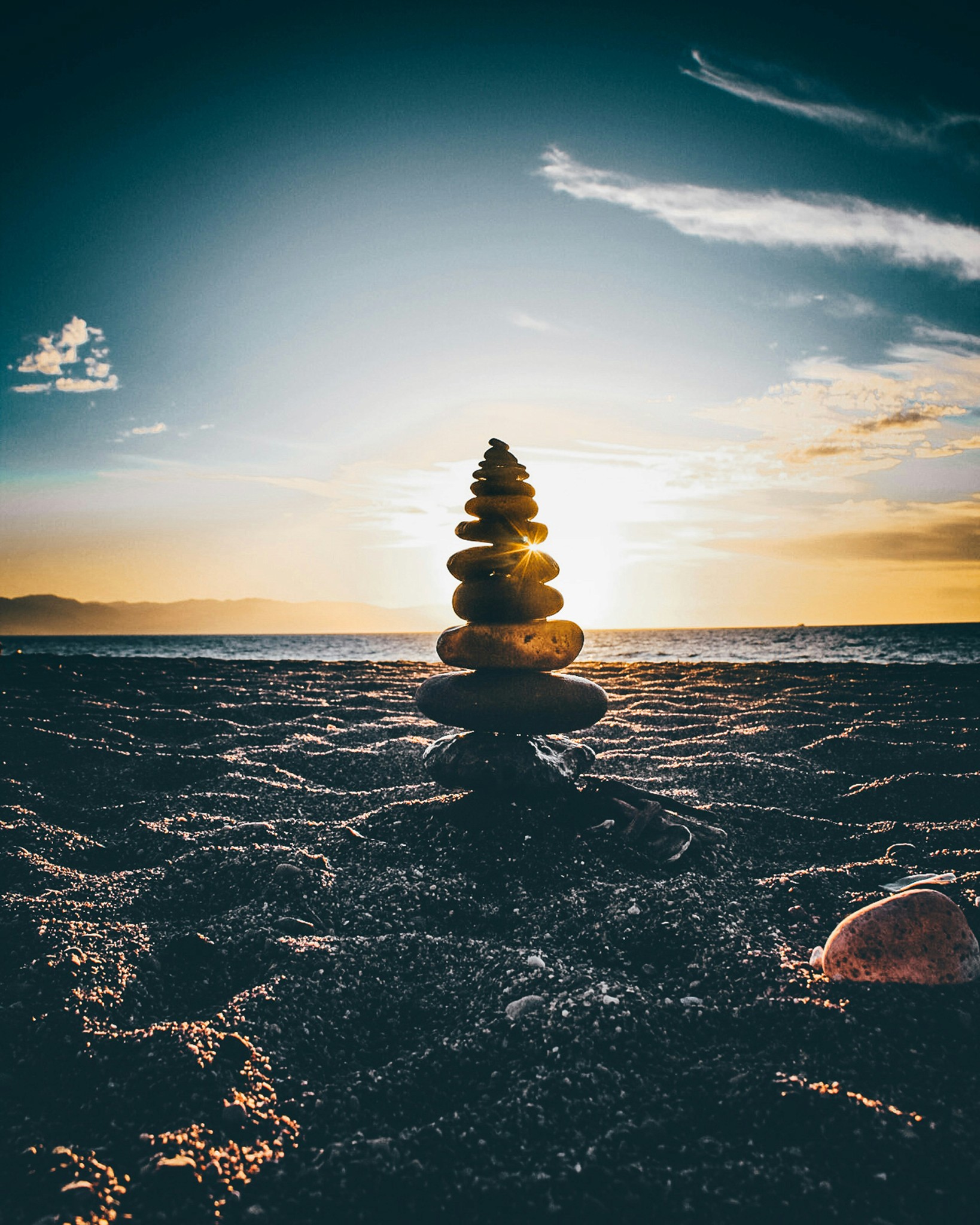 Seven stones stacked and in focus on a beach