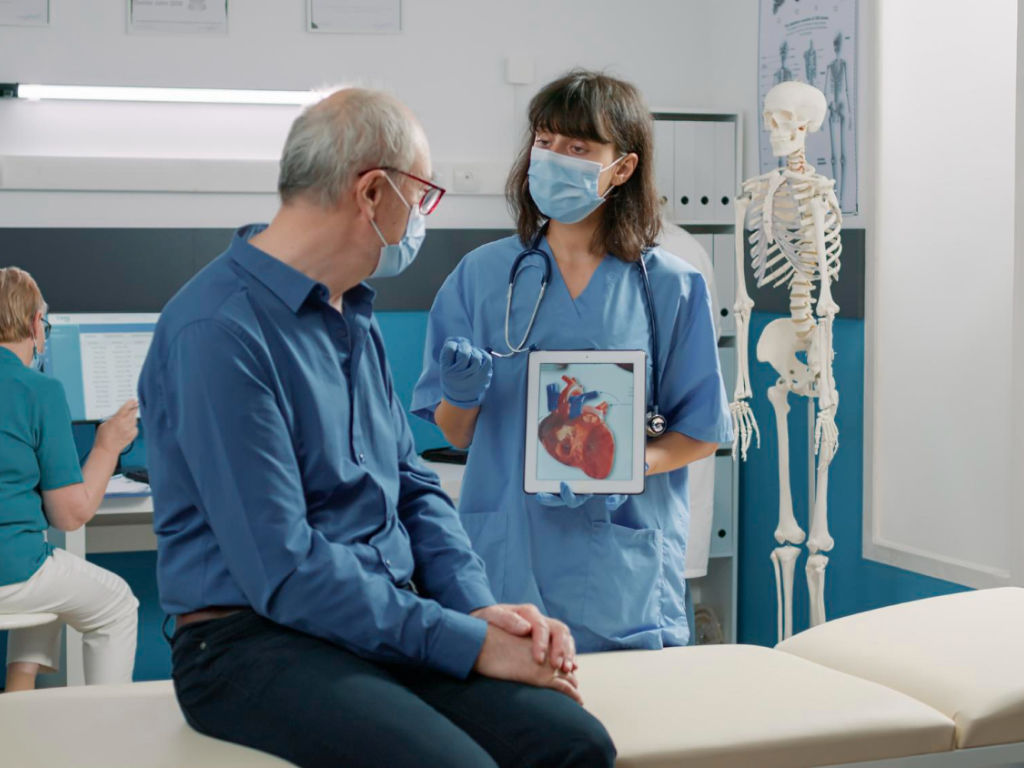 A doctor and patient in a hospital room.