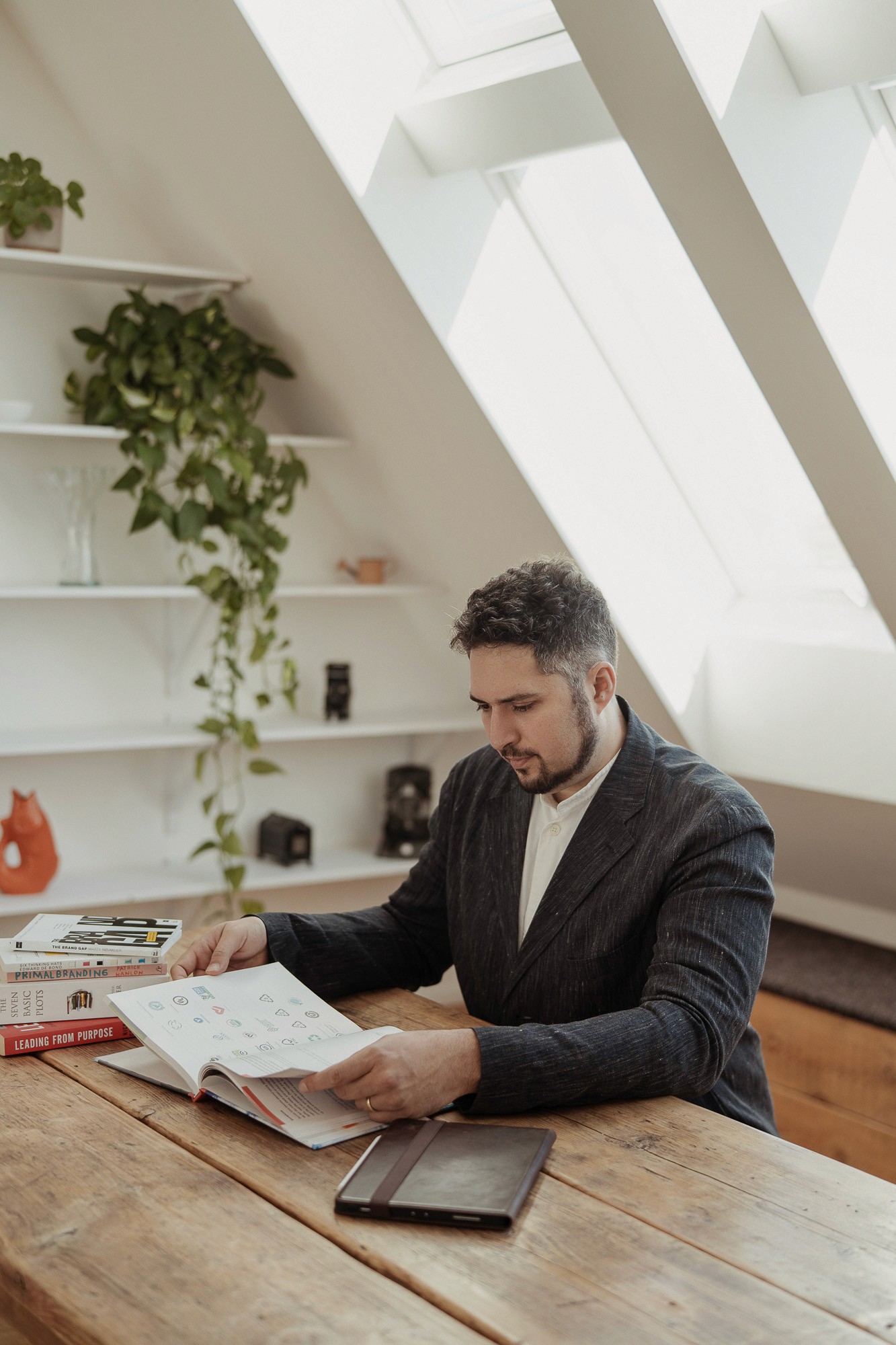 StoryOS founder reviewing strategy and branding research materials in a light-filled workspace
