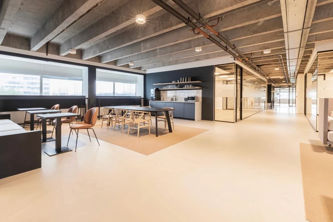 Bedrijfskantine met houten stoelen en lange tafels