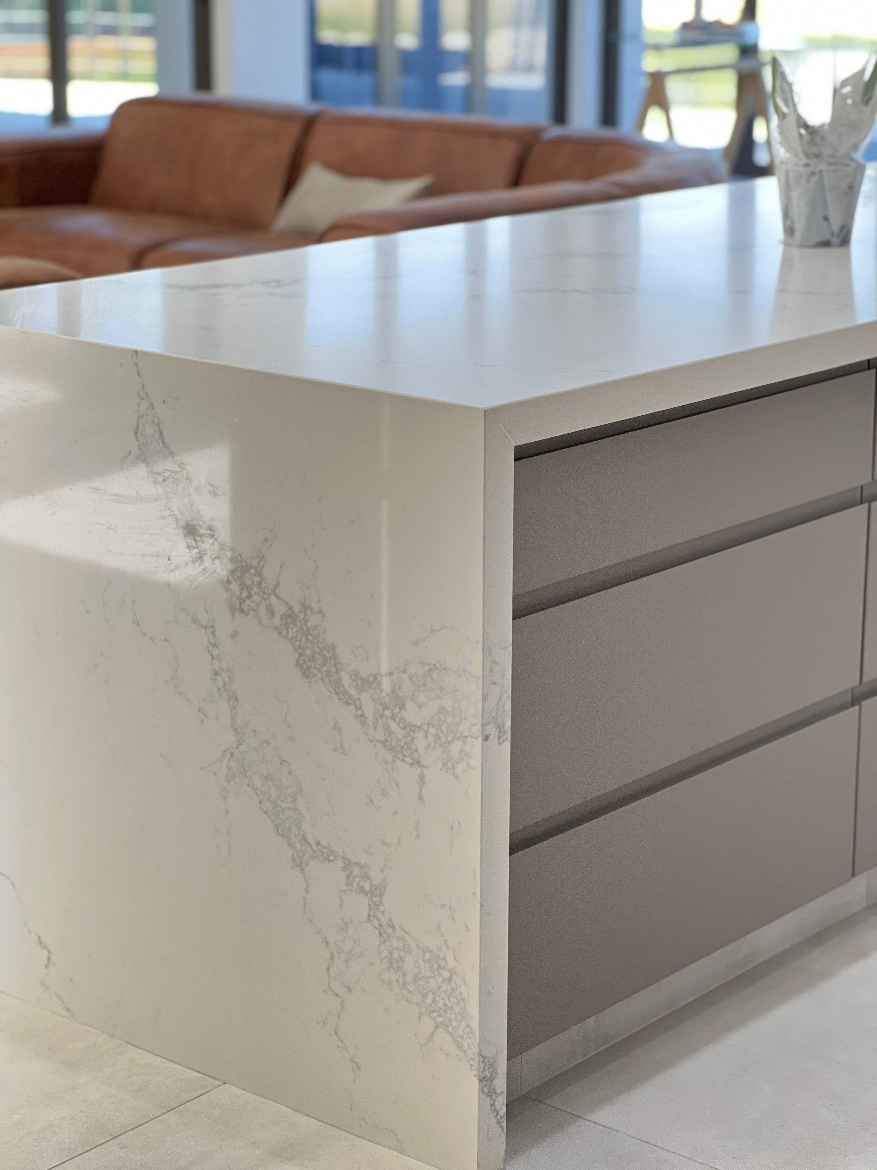 Modern interior entrance with floor-to-ceiling glass walls and warm timber cladding overlooking landscape