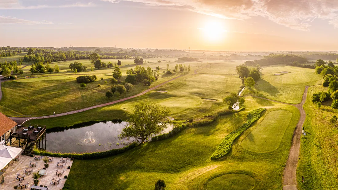 Golf course and pond at sunrise.